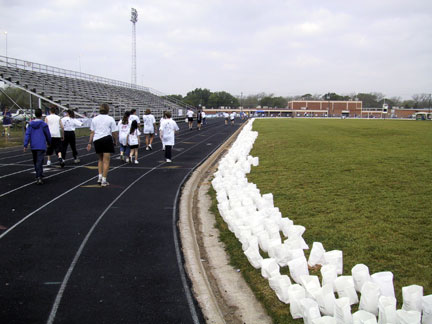 View of some walkers and the  luminaries that circle the entire football field. During the luminary ceremony, the lights at the football field are turned off and candles are lit in each luminary. Each luminary is a memorial or honors a survivor and helps raise funds in the fight against cancer. It takes many groups, individuals, special sponsors and organizations working together to raise the dollars needed in the fight against cancer! UNTIL NEXT YEAR! 