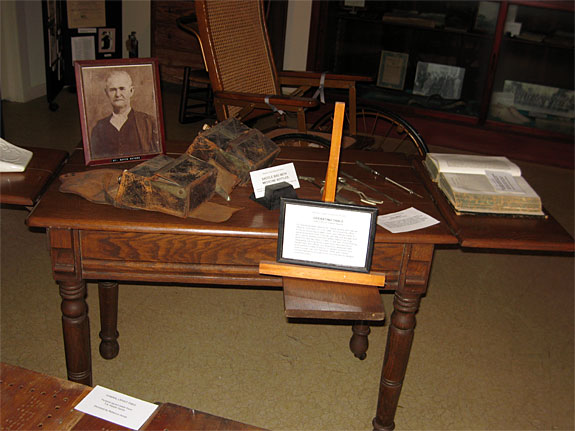 Dr. David Sayers examining table and medical bags with medical instruments.